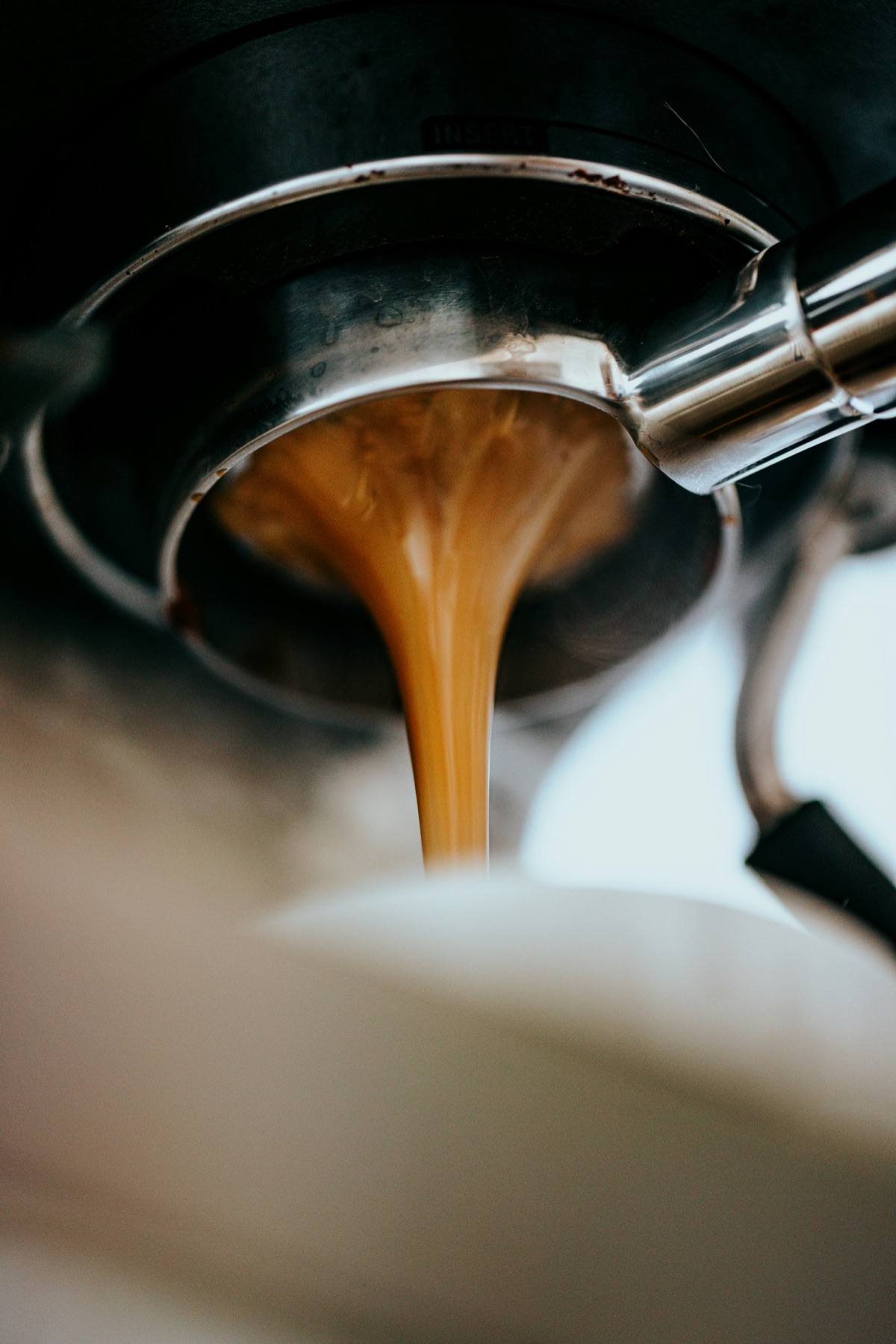 A fresh shot of espresso pulling into a cup